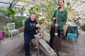 Participants and staff take part in a besom broom making workshop, hosted at the greenhouses