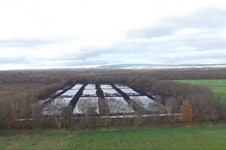 Aerial view of the re-wetted field showing long rectangular compartments holding standing water