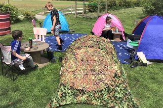 Children and tents in a sunny field 