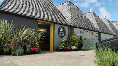 A view of the entrance to Kestrel Kitchen, with lots of plants surrounding the doorway.