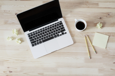 Post-it notes and black coffee next to a laptop computer