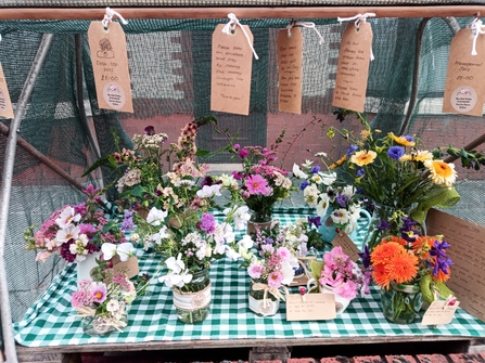 Vases of colourful flowers at a market stall