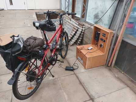 An electric bike being charged by a solar panel