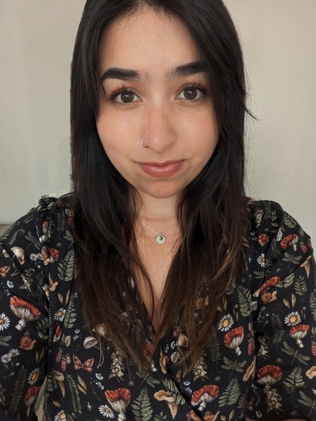 A woman with dark hair looking into camera