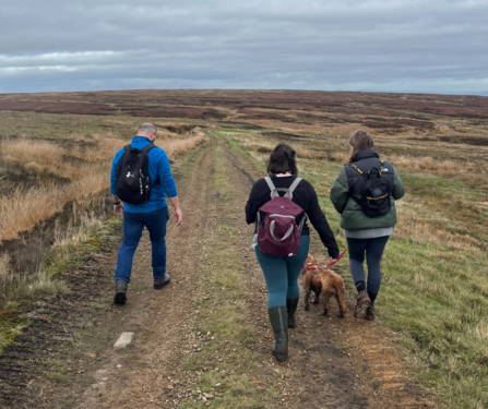 Alex, Megan and Lucy walking down a hill on a path at Darwen Moor