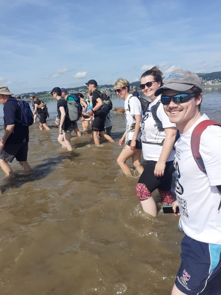 Lorna, Danny and Becky walking in the sea along Morecambe Bay