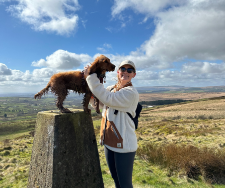 Lucy and Winnie her dog standing on a podium with a blue sky behind