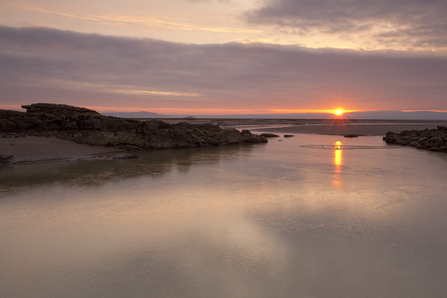 Estuarine river inlet meandering through mudflats across Morecambe Bay