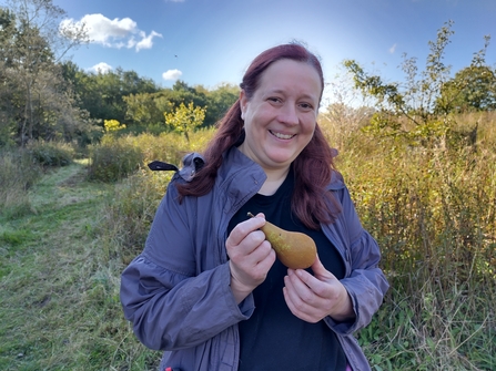 Volunteer Swin holding a green pear