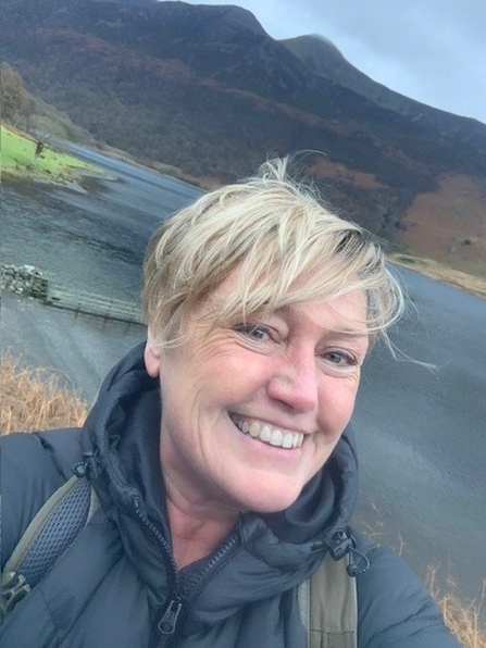 A woman standing in front of a lake