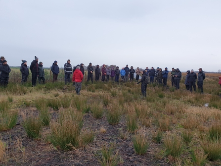 A group of people listening to a talk at the carbon farm