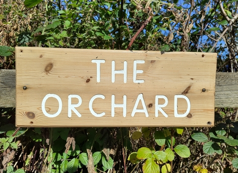 Wooden sign reading The Orchard